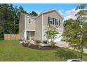 Two-story house with beige siding, white garage door, and landscaped yard at 141 Lagoona Dr, Summerville, SC 29483