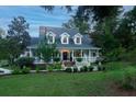 Two-story home with wrap-around porch and fountain at 6949 Maybank Hwy, Wadmalaw Island, SC 29487