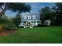 Two-story home with wrap-around porch and fountain at 6949 Maybank Hwy, Wadmalaw Island, SC 29487