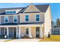 Two-story tan townhome with a front porch, gray trim and a two-car driveway at 229 Abercom Place Dr, Moncks Corner, SC 29461