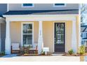 Inviting front porch with two chairs and a dark brown door at 229 Abercom Place Dr, Moncks Corner, SC 29461