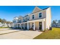 Row of townhomes with front porches, landscaping, and individual driveways at 229 Abercom Place Dr, Moncks Corner, SC 29461