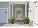 Inviting front entrance with a cheerful yellow door, flanked by planters and stone accents at 377 Tupelo Lake Dr, Summerville, SC 29486