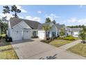 Light blue three-car garage home with stone accents and manicured landscaping at 377 Tupelo Lake Dr, Summerville, SC 29486
