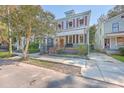 Charming two-story home with light blue siding, red shutters, and a brick walkway at 380 Ashley Ave, Charleston, SC 29403