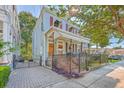 Charming two-story home with light blue siding, red shutters, and a brick walkway at 380 Ashley Ave, Charleston, SC 29403