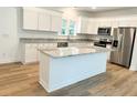 Modern kitchen with white cabinets, granite counters, and an island at 102 Whitesville Rd, Moncks Corner, SC 29461