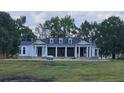 Newly built home with white siding, dark roof, and front porch at 210 Oyster Catcher Ln, Ravenel, SC 29470