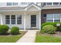 Townhome entry with glass door, neutral siding, and manicured landscaping at 107 Darcy Avenue, Goose Creek, SC 29445