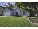 Gray house with a well-maintained lawn and landscaping at 115 Cairnwell Pass, Goose Creek, SC 29445