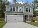 Two-story house with green siding, white garage door, and landscaping at 316 Bay Village Ln, Moncks Corner, SC 29461