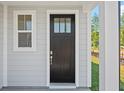 Modern black front door with glass panels and sidelight at 425 Grove End Rd, Moncks Corner, SC 29461