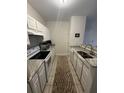 Galley kitchen with granite countertops and white cabinets at 1600 Long Grove Dr # 628, Mount Pleasant, SC 29464