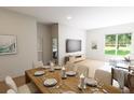 Open concept dining area with seating for eight and view into living room at 7421 Indigo Palms Way, Johns Island, SC 29455