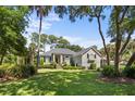 Beautiful two-story home with gray siding, black shutters and spacious lawn at 2340 Marsh Hen Dr, Seabrook Island, SC 29455