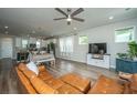 Open living room with brown leather sectional sofa, hardwood floors, and large TV at 210 Winding River Dr, Johns Island, SC 29455