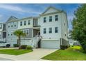 Two-story townhome with attached garage and American flag at 210 Winding River Dr, Johns Island, SC 29455