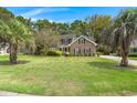 Two-story brick home with a spacious lawn and palm trees at 107 Forest Glenn Ct, Summerville, SC 29485