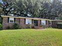 Brick ranch home with mature trees and lawn at 2320 S Lander Ln, Charleston, SC 29414