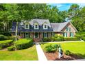 Brick home with green shutters and landscaped yard at 10 Trail Hollow Dr, Charleston, SC 29414