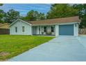 Newly renovated light gray house with a spacious gray driveway and lawn at 133 Marion Rd, Summerville, SC 29486