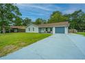 Newly renovated light gray house with a gray driveway and well-maintained lawn at 133 Marion Rd, Summerville, SC 29486