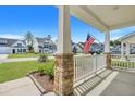 Front porch view of charming neighborhood with American flag and stone pillars at 516 Yellow Leaf Ln, Summerville, SC 29486