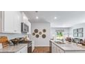 Bright kitchen boasts white cabinets, granite counters, and gas range at 5528 Bowmore Blvd, Ravenel, SC 29470