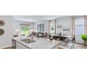 Open kitchen with granite island, double sink, and view into adjacent living area at 5528 Bowmore Blvd, Ravenel, SC 29470
