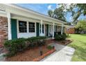 Brick home with green shutters, white columns, and landscaping at 117 Wessex Dr, Goose Creek, SC 29445