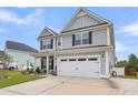 Two-story gray house with white garage door and a well-manicured lawn at 515 Alderly Dr, Moncks Corner, SC 29461