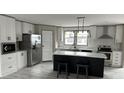 Modern kitchen with white cabinets, a large island, and stainless steel appliances at 928 Tiger Loop, Saint Stephen, SC 29479