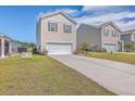 Two-story tan house with white garage door and landscaping at 124 Blossom Wood Ln, Summerville, SC 29486