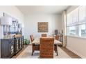 Bright dining room with a farmhouse table, wicker chairs, and large windows at 150 Carolina Groves Blvd, Moncks Corner, SC 29461