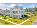 Two-story light blue house with a wrap-around porch, well-manicured lawn, and tree-lined streets at 112 Archdale St St, Summerville, SC 29486