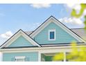 Close-up view of a light blue house's roofline and dormer window at 112 Archdale St St, Summerville, SC 29486