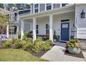 Inviting front porch with rocking chairs, landscaping, and a blue door at 112 Whitetail Rd, Summerville, SC 29483