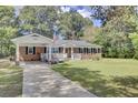 Brick ranch house with carport, front porch, and landscaped lawn at 1510 Jahnz Ave, Summerville, SC 29485