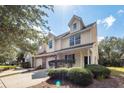 Tan two-story townhome with two-car garage and manicured landscaping at 1151 Saint Pauls Parrish Ln, Johns Island, SC 29455