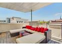 Rooftop patio with sectional seating, red pillows, and city views at 487 King St # 202 Penthouse, Charleston, SC 29403