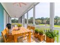 Screened porch with wooden dining table and chairs, overlooking a garden at 3238 Plow Ground Rd, Johns Island, SC 29455