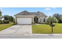 Charming tan house with white garage door and landscaping at 586 Eastern Isle Ave, Summerville, SC 29486