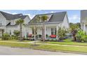 White cottage with a porch and palm trees at 661 Blueway Ave, Summerville, SC 29486