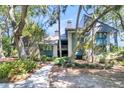 Two-story home with gray siding, blue accents, and landscaping at 4910 Green Dolphin Way, Kiawah Island, SC 29455