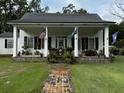 White house with black metal roof and porch at 106 Church St, Reevesville, SC 29471