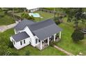 White house with black metal roof, porch, and pool at 106 Church St, Reevesville, SC 29471