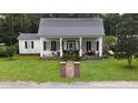 White house with black metal roof and porch at 106 Church St, Reevesville, SC 29471