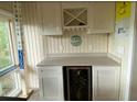 A built-in wet bar with white cabinets, wine rack, and a mini-fridge at 818 Club Cottage Court, Edisto Beach, SC 29438