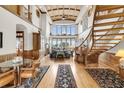 High-ceilinged living room with hardwood floors, a curved staircase, and ample natural light at 1408 Palmetto Blvd, Edisto Island, SC 29438