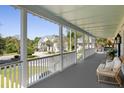 Spacious front porch with white columns, wicker furniture, and view of neighborhood at 3583 Somerset Hills Ct, Mount Pleasant, SC 29466